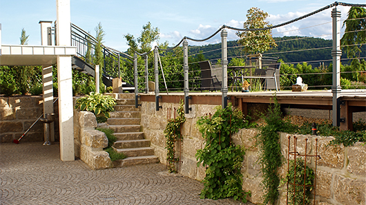 Kreative Gartengestaltung mit Terrasse und Mauer von Bergmann Galabau